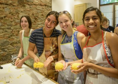Students smiling and holding dough during a cooking class