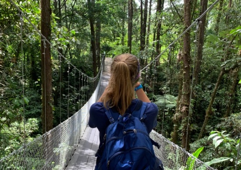 Student with backpack walking across bridge in Costa Rica tropics