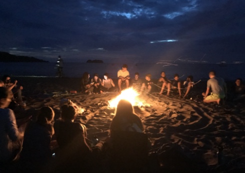 Students around a campfire at night on Costa Rican beach